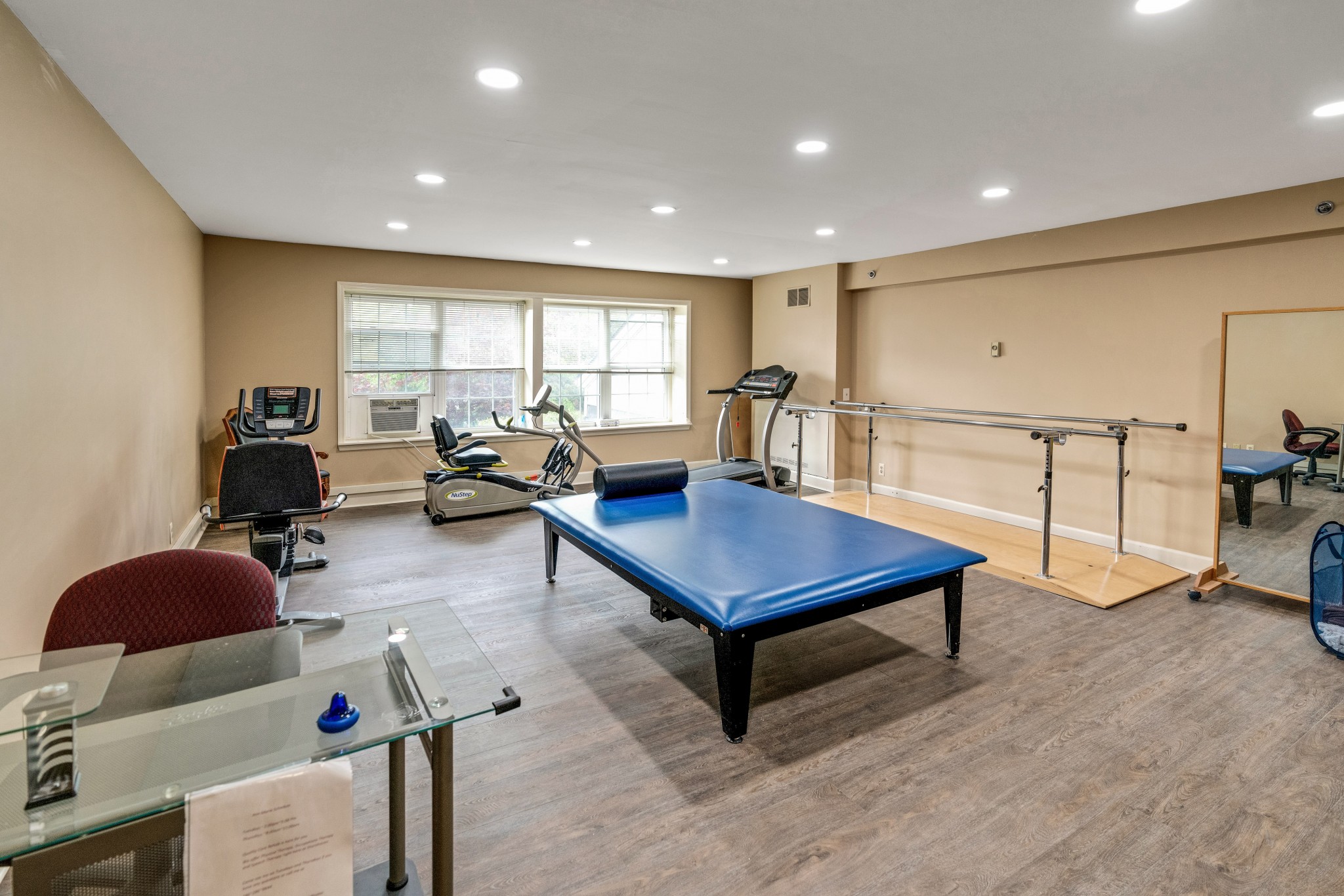 A gym room with exercise machines, poles, and mats at Shorehaven, a senior living community near Washington Township.