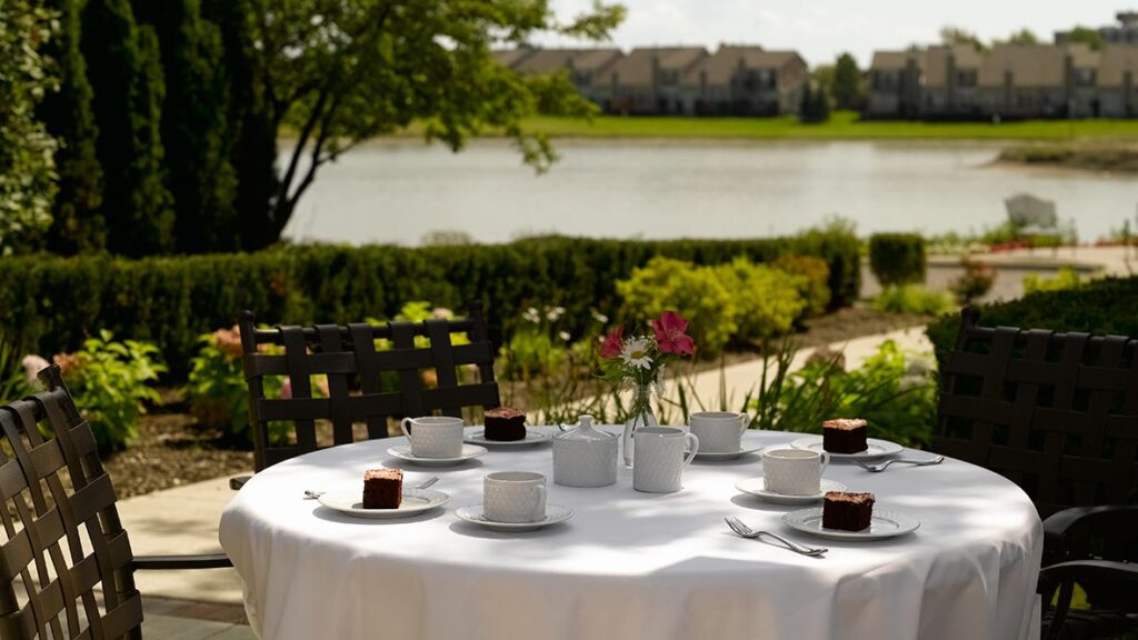 An outdoor dining table with a view of the lake at Shorehaven, a senior living community near Washington Township.