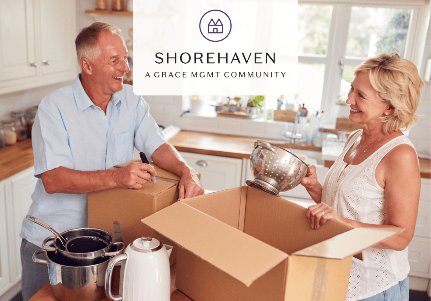 Smiling elderly couple packing a kitchen and loading items into cardboard boxes, preparing to move in a bright home.